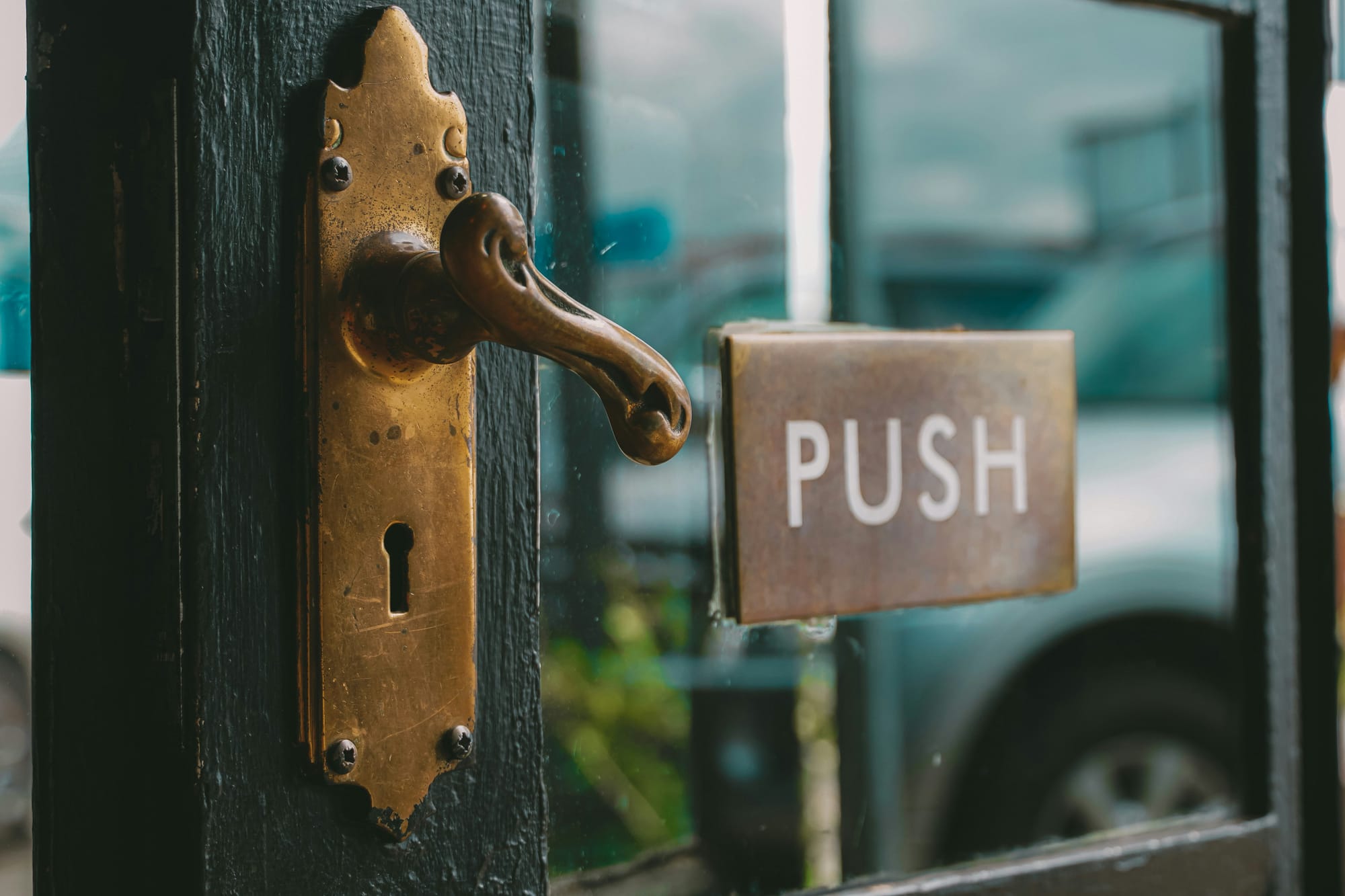 Door, slightly ajar, with a sign that reads "Push"