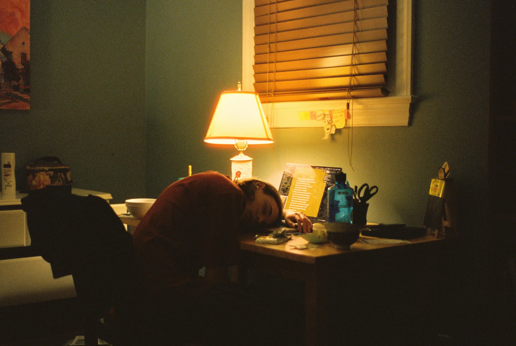 Woman slumped over her computer, asleep at her desk