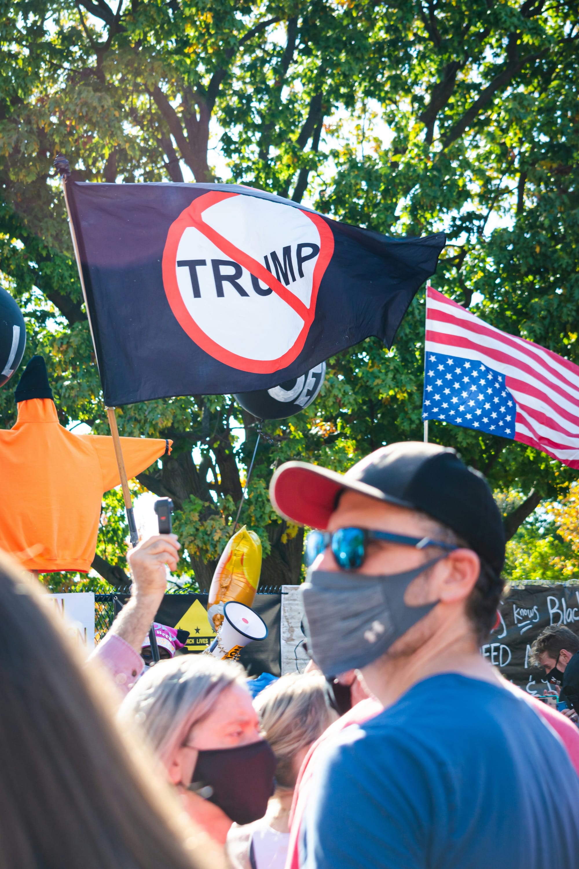 Protestors, featuring an anti-Trump sign and upside-down flag