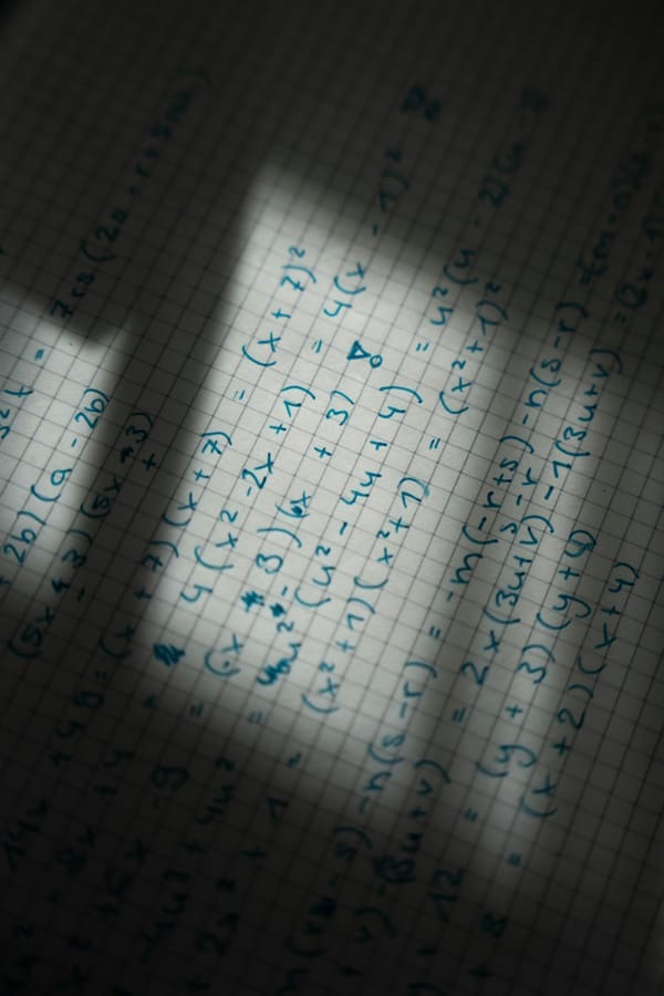 Graph paper with handwritten equations, seen in shadow