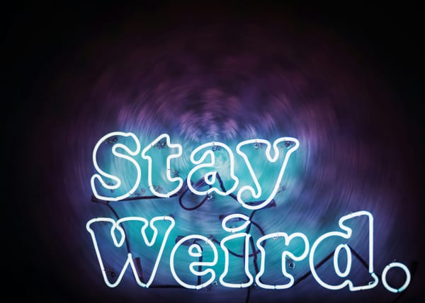 Neon sign stating "Stay Weird."